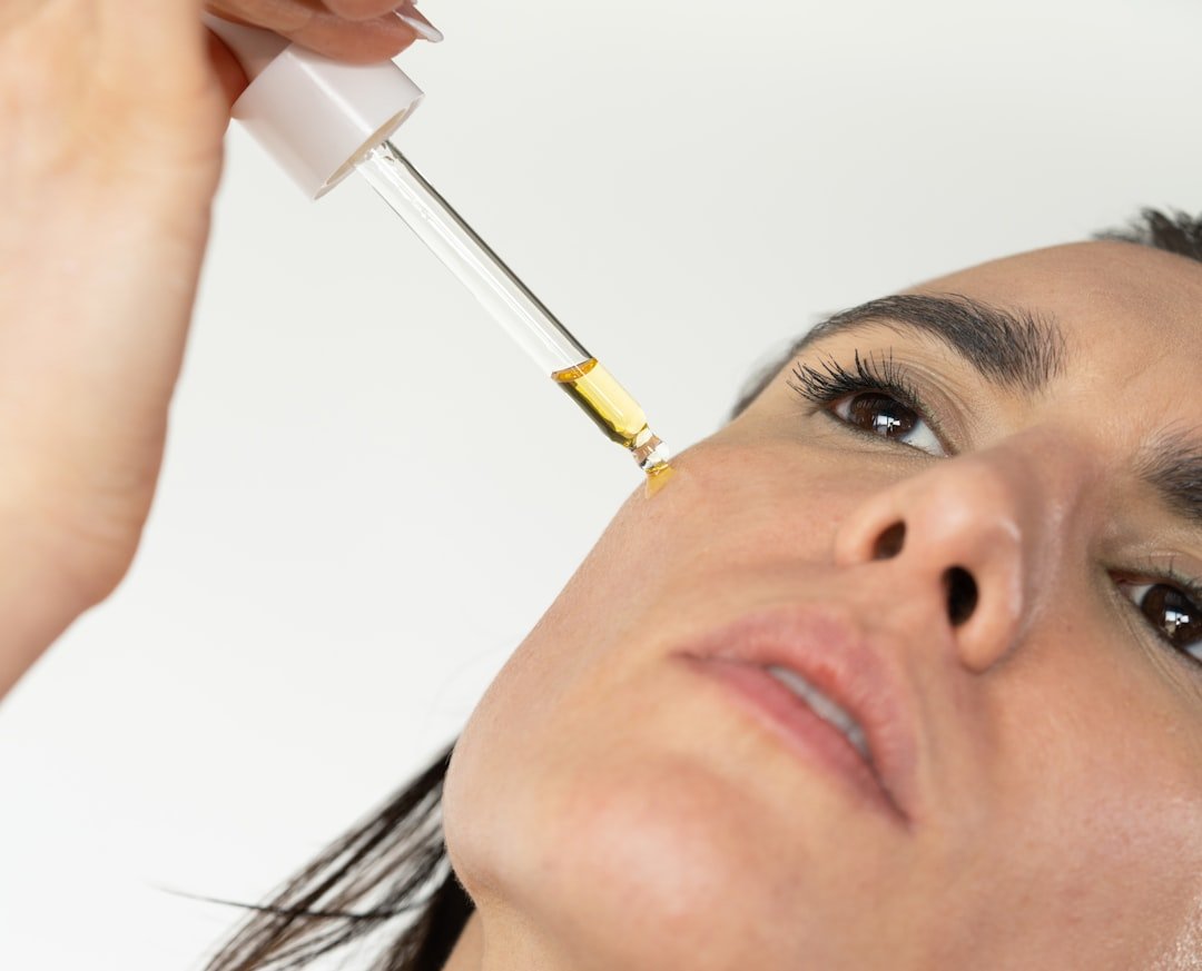 cbd oil for migraines - Person reading wellness journal whilst holding CBD oil bottle, representing the importance of trac...