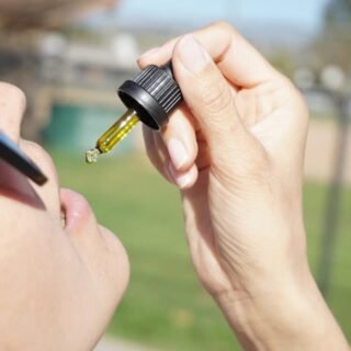 cbd oil flavors - Person examining different CBD oil bottles with various natural flavours