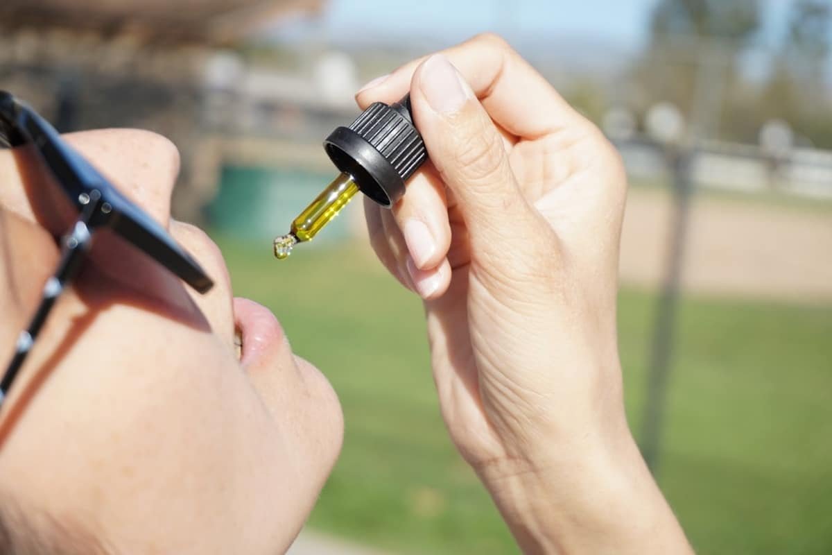 cbd oil flavours - Person examining different CBD oil bottles with various natural flavours