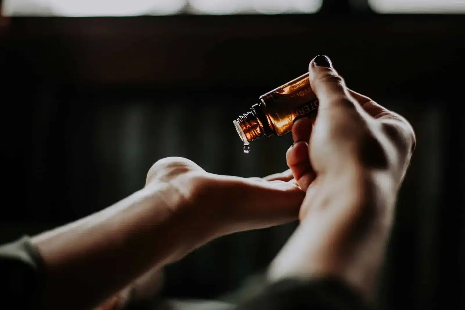Amber dropper bottle held over an open hand