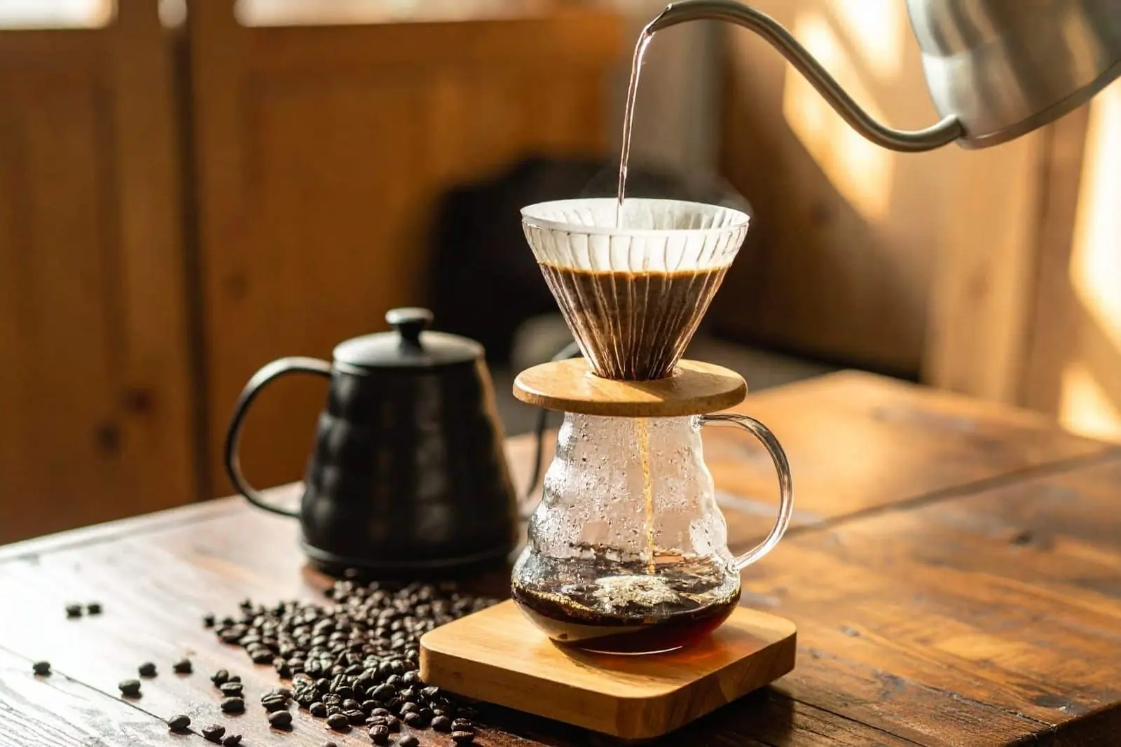 Pour-over coffee dripping into a glass carafe on a wooden table