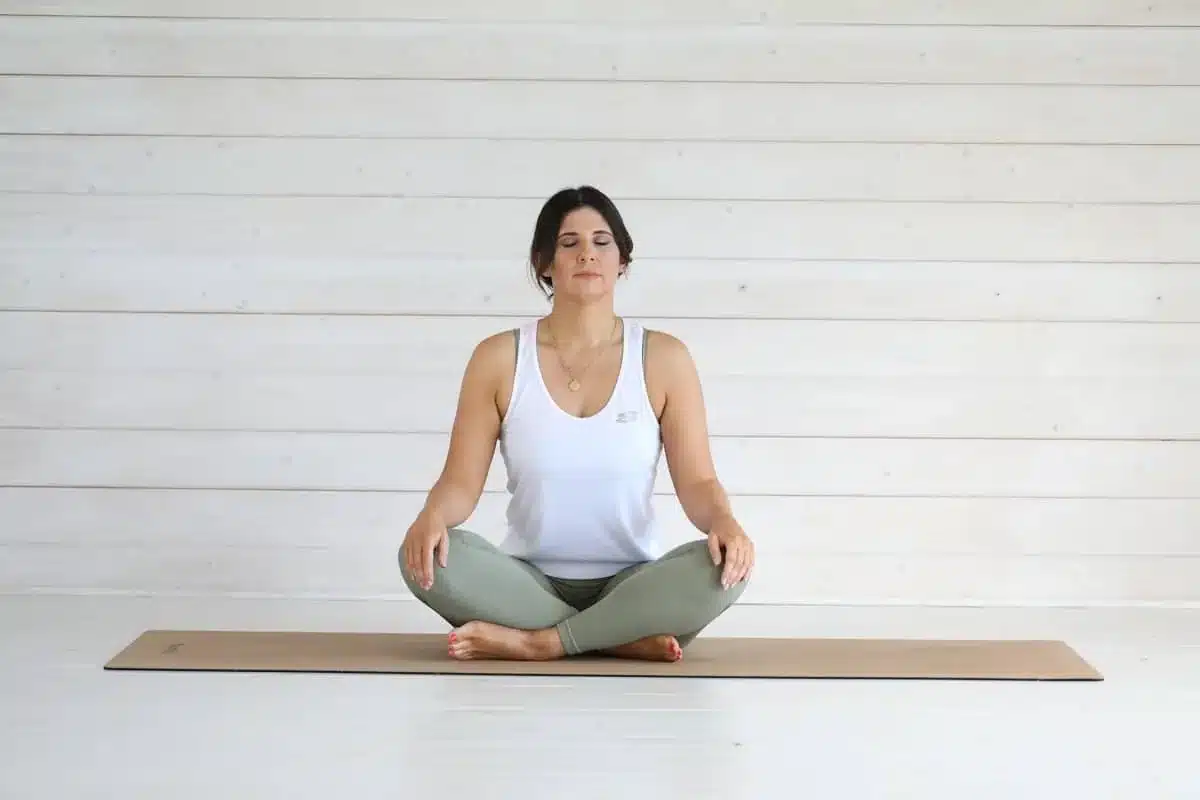 Woman sitting cross-legged on a yoga mat